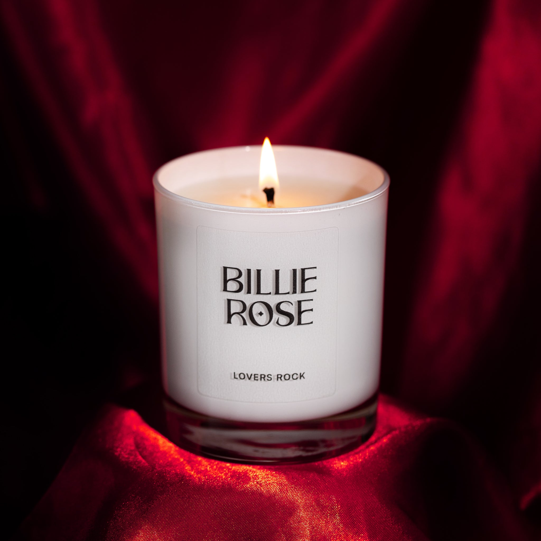 Billie Rose candle on a red fabric background
