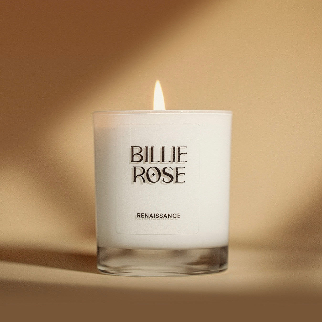 Billie Rose candle with a warm glow on a golden background