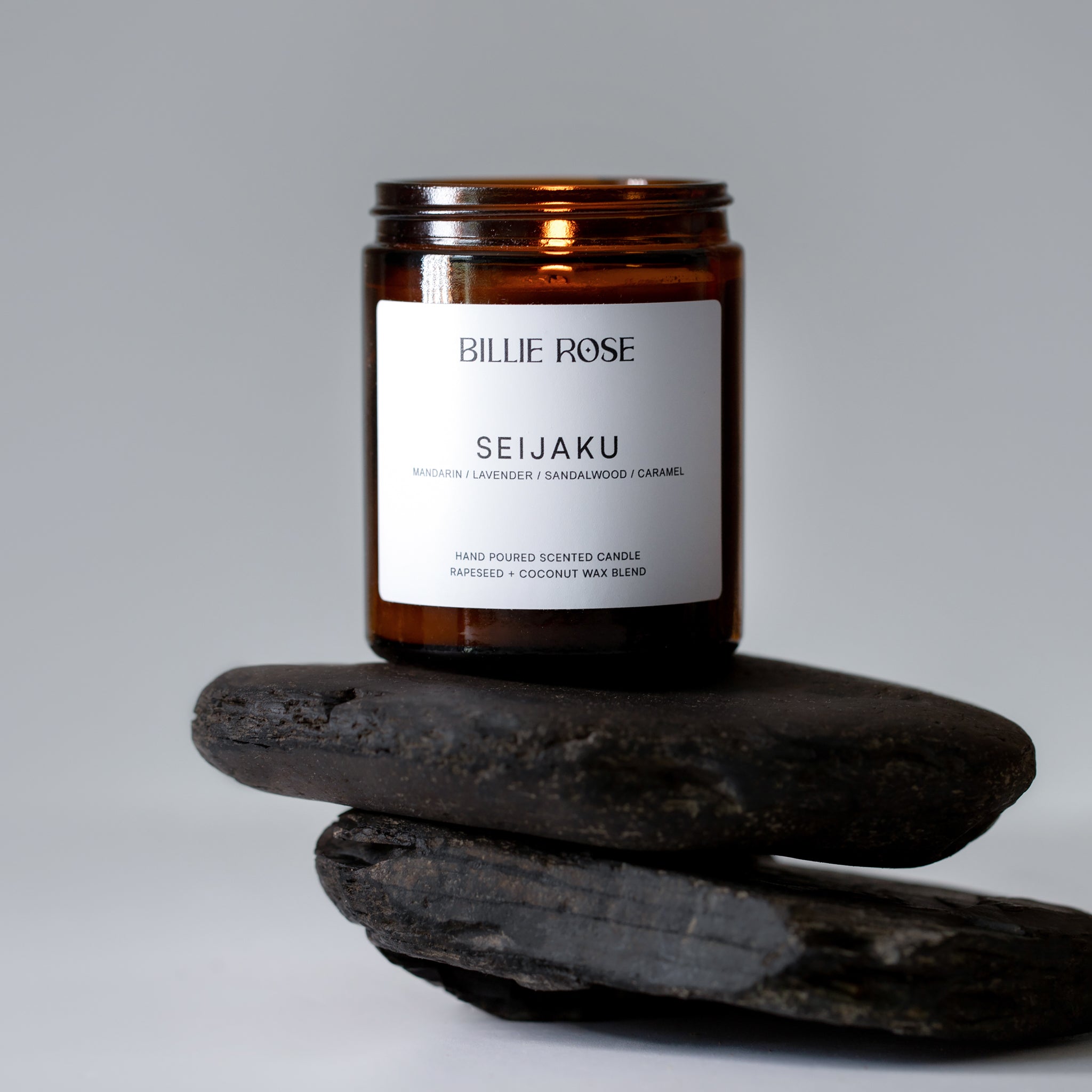 lit scented candle on pebbles, calming, relaxing background