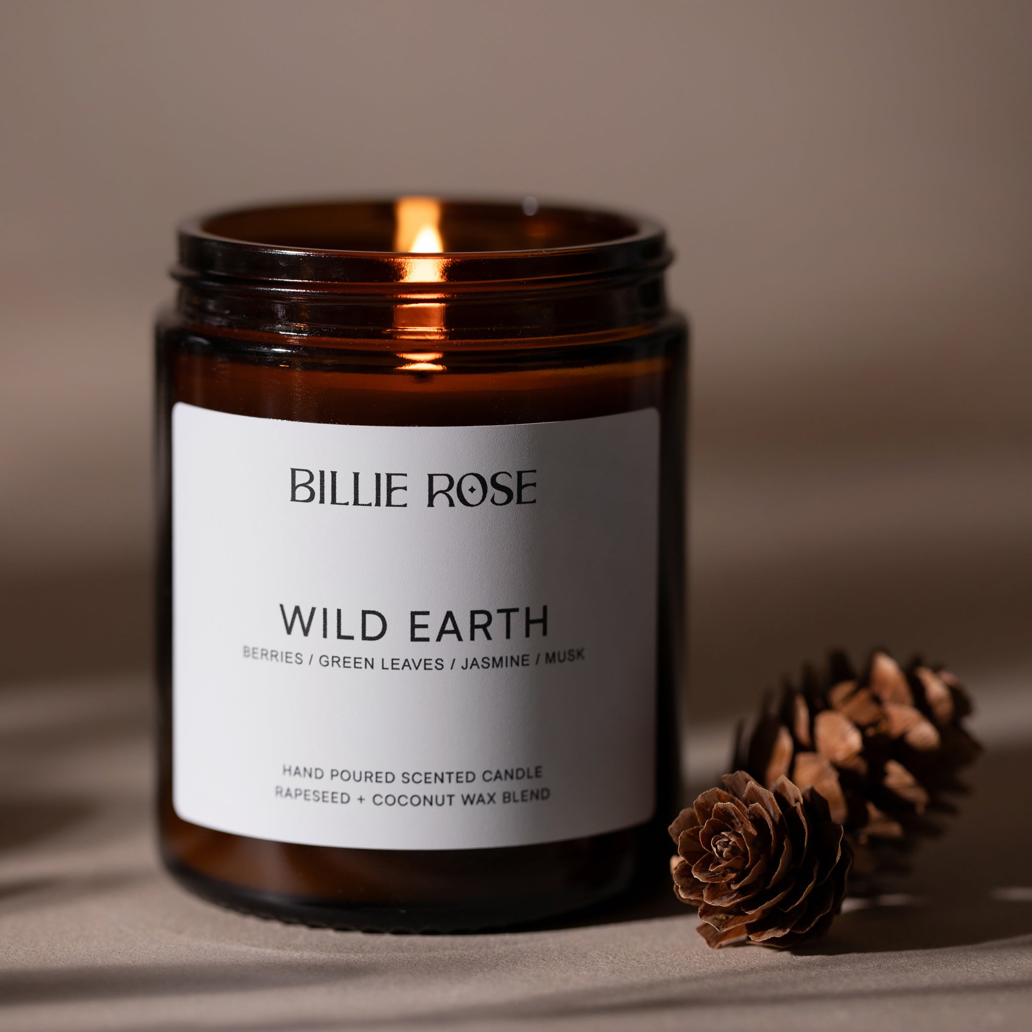 lit scented candle on earthy brown background