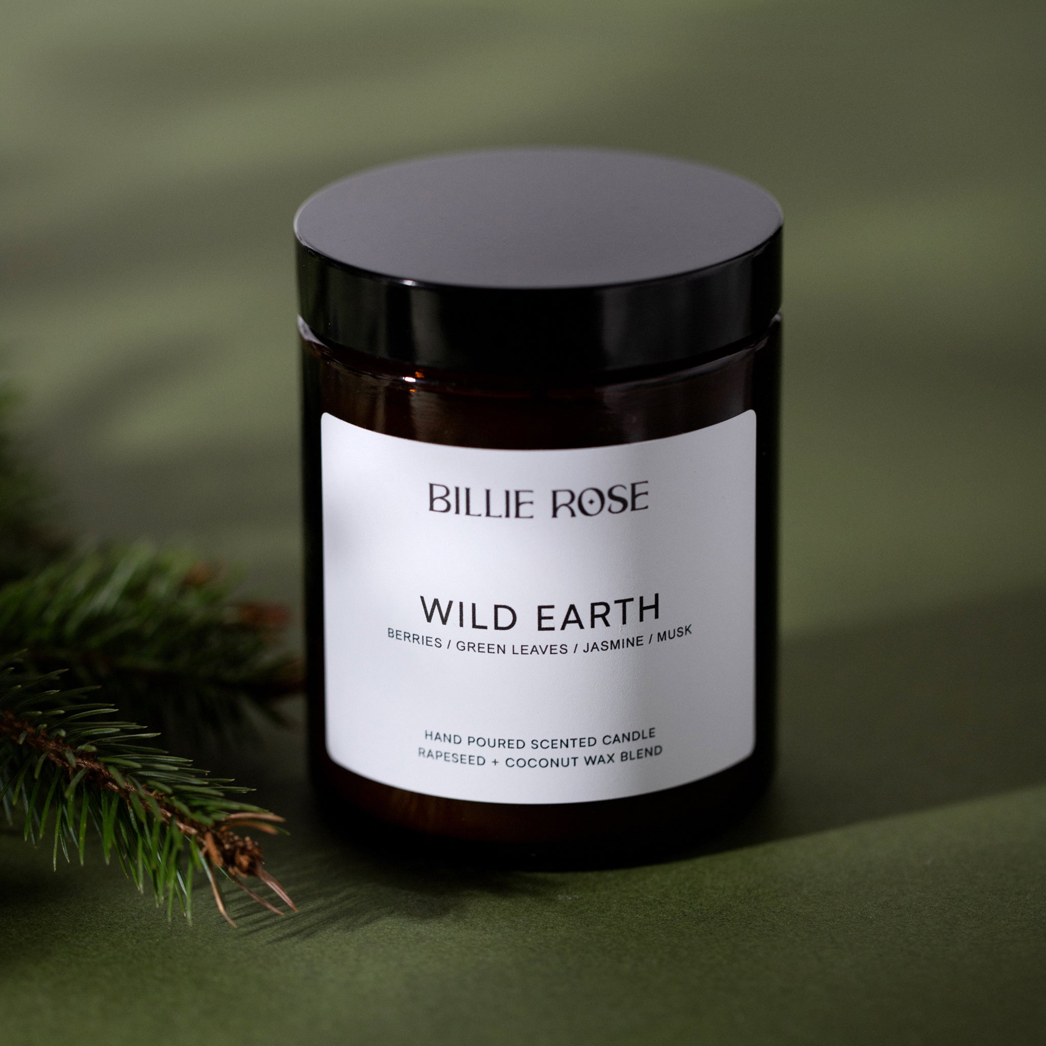 amber jar candle with lid on green background