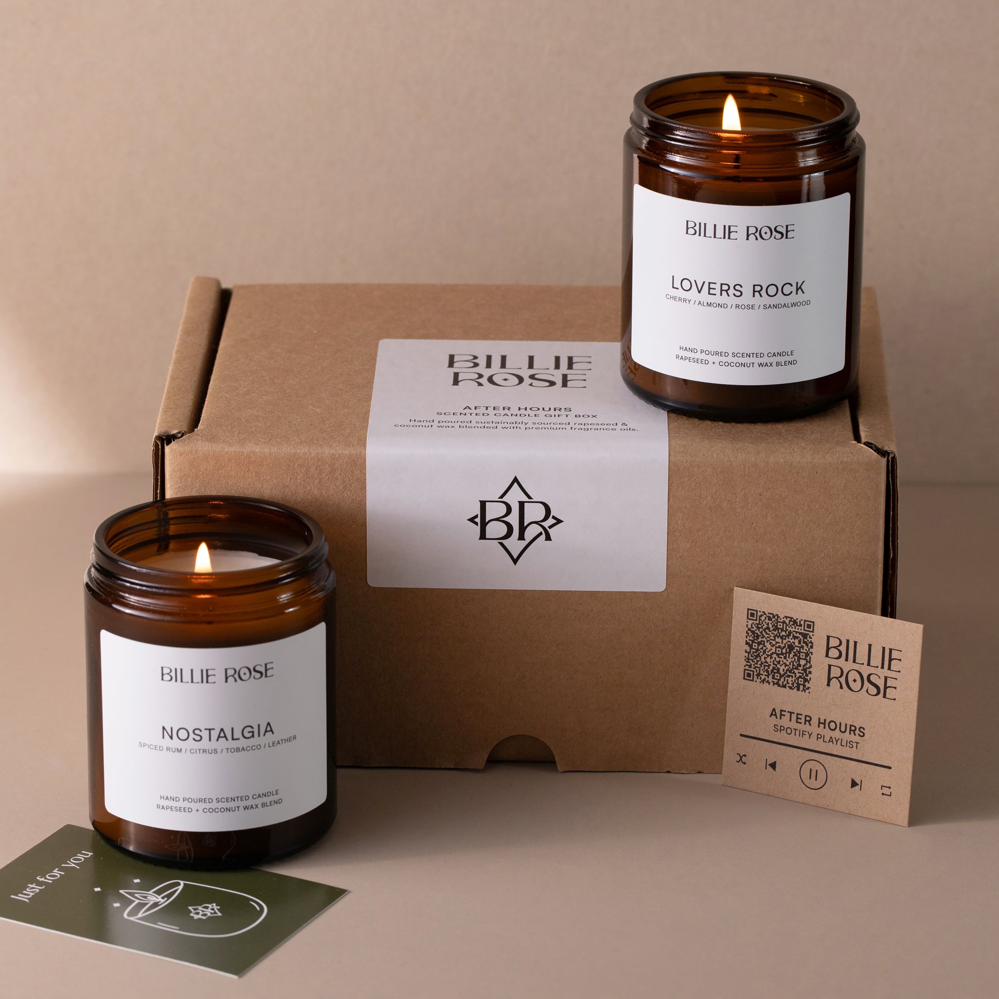 Two lit candles with 'Billie Rose' branding on a Kraft cardboard box and gift card.