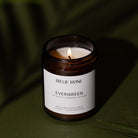 Candle in a jar labeled 'Evergreen' by Billie Rose on a dark background