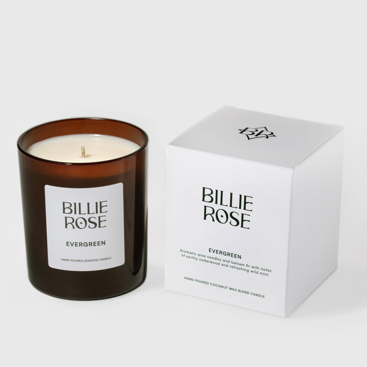 An amber glass jar candle labelled Billie Rose Evergreen next to its white product box on a light grey background.