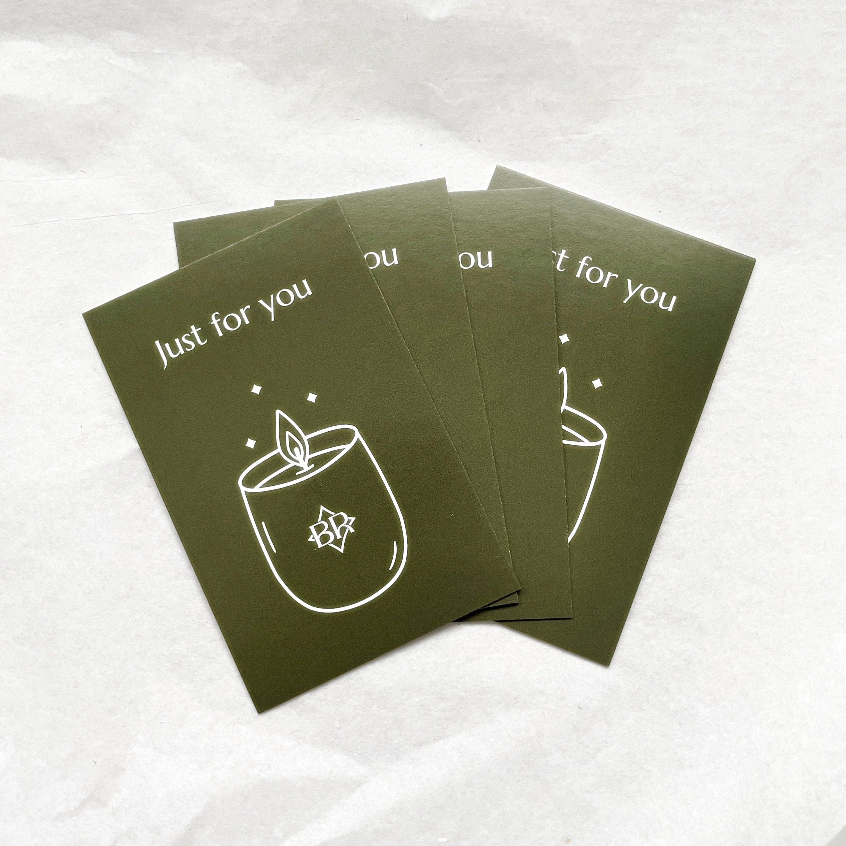 Stack of green cards with a candle illustration and 'Just for you' text on a white background