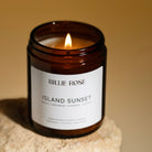 lit candle on rock with orange background