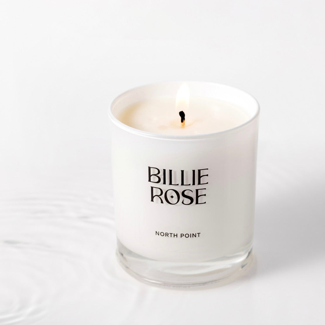 White candle in a glass container with 'Billie Rose' branding on a white background
