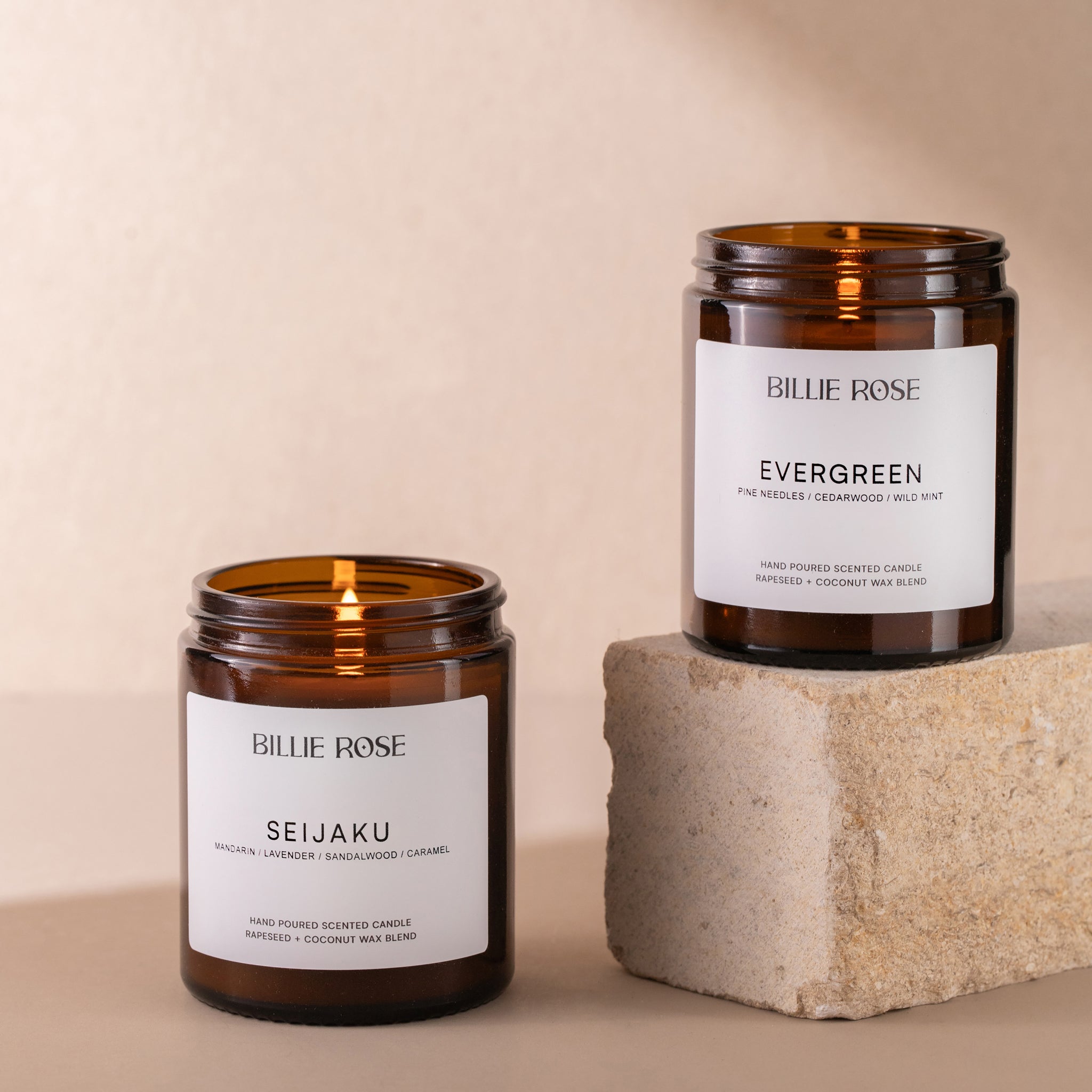 Two Billie Rose candles, one labelled 'Seijaku' and the other 'Evergreen', on a beige background.