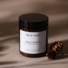 scented candle with lid on earthy brown background