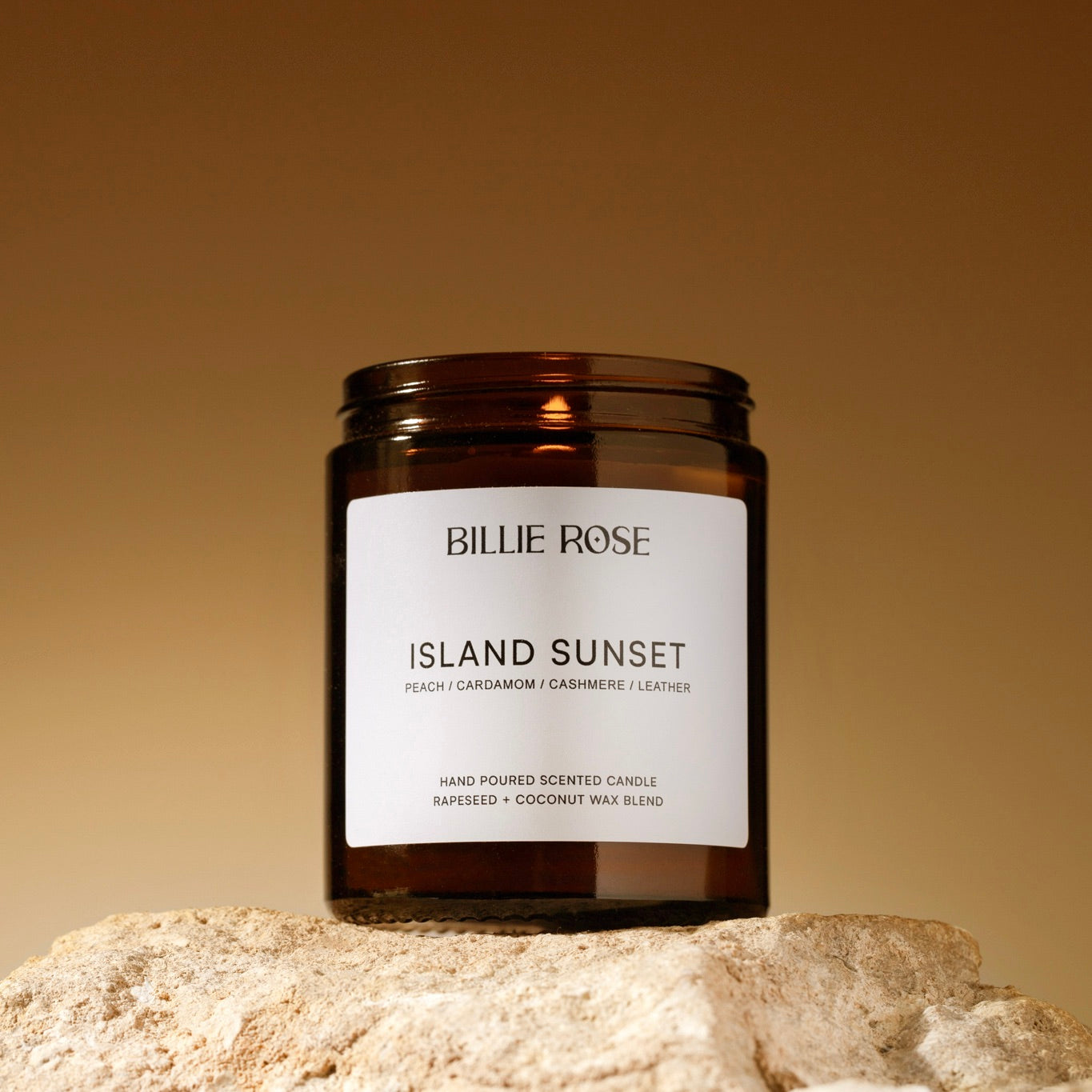 lit candle on rock and sunset style background